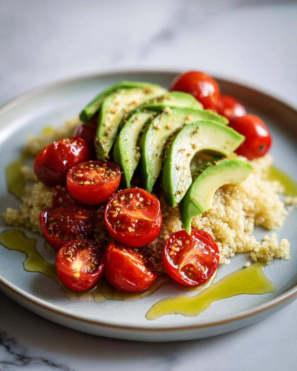 A vibrant plate featuring quinoa topped with sliced avocado and halved cherry tomatoes, showcasing a beautiful cooking aesthetic.