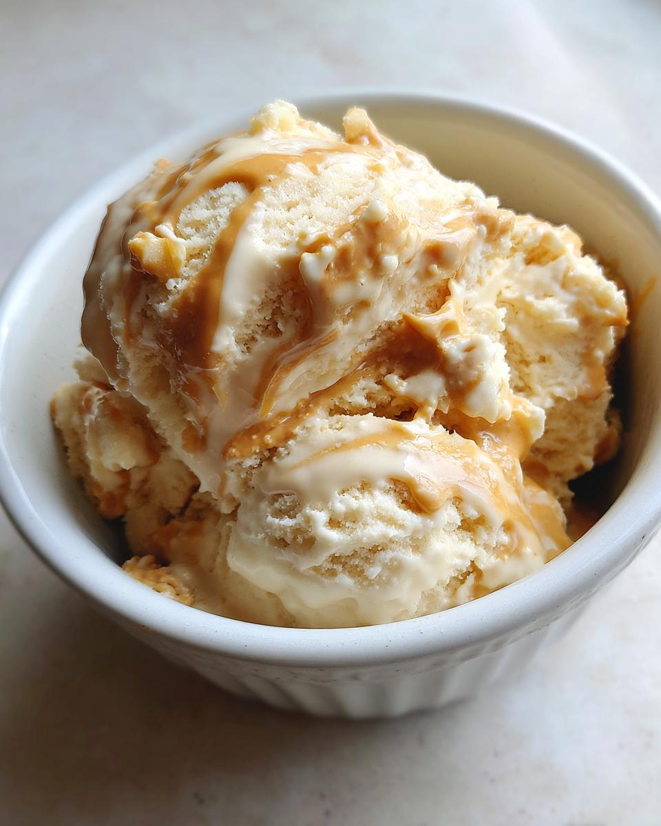 Close-up of creamy banana nice cream with peanut butter swirl in a white bowl.