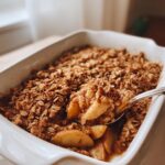 White baking dish with easy baked cinnamon apple crisp topped with oat crumble