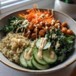 Buddha bowl recipes featuring quinoa, roasted chickpeas, kale, cucumber, and shredded carrots with dressing