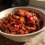 White bowl filled with ground beef tomato stew with onions, perfect for cozy dinner recipes