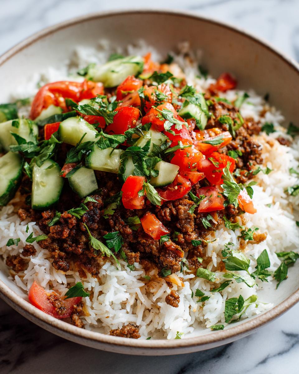 Rice bowl with seasoned ground meat, chopped tomatoes, cucumbers, and fresh herbs for march ramadan easy weeknight iftar