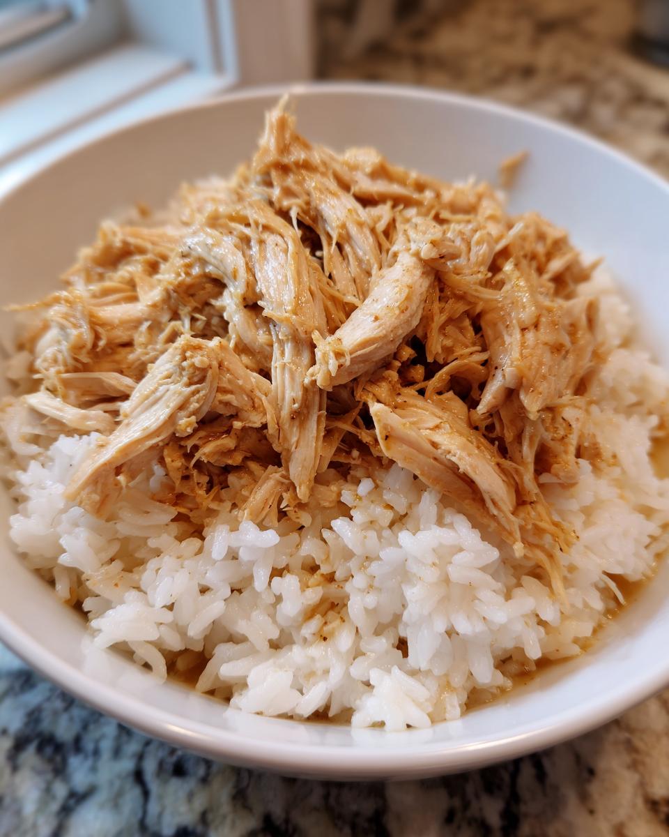 Bowl of shredded chicken served over white rice, a simple instant pot recipe meal.