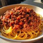 Bowl of spaghetti topped with rich meat sauce, perfect for family dinner ideas