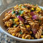Close-up of BBQ ranch pasta salad recipe with rotini pasta, corn, black beans, red onion, and cilantro.