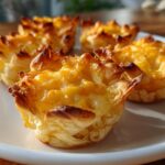 Close-up of golden baked cheesy easy finger food snacks on a white plate.