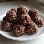 Close-up of chocolate hazelnut snack bites with oats on a white plate