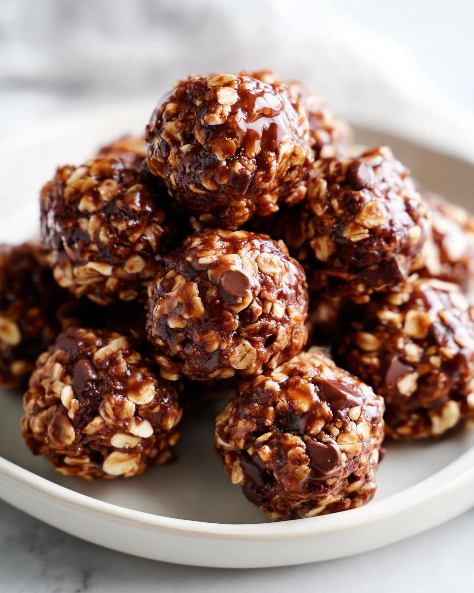 Close-up of chocolate hazelnut snack bites with oats and chocolate chips stacked on a white plate