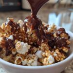 Bowl of chocolate marshmallow popcorn with chocolate being drizzled on top