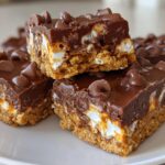 Close-up of chocolate marshmallow sweet party treats stacked on a plate.