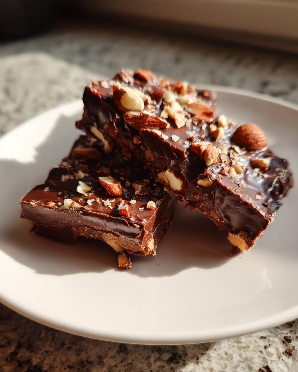 Close-up of chocolate nut bark pieces on a white plate, a perfect spring chocolate treats snack.