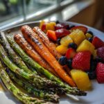 Plate with grilled asparagus, roasted carrots, and fresh fruit salad for Easter brunch side dishes