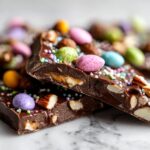 Close-up of Easter chocolate bark ideas with colorful candy eggs, nuts, and sprinkles on chocolate pieces.