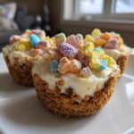 Close-up of Easter mini egg desserts with creamy filling and colorful candy toppings on a white plate.