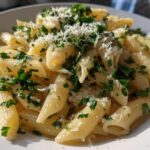 Plate of easy pasta side dishes with penne, chopped parsley, and grated Parmesan cheese.