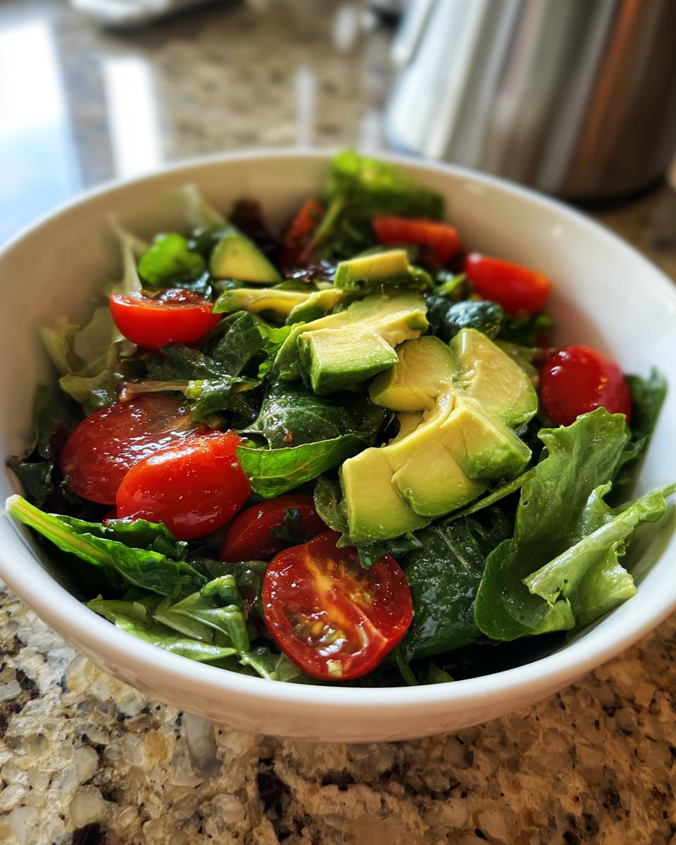 Bowl of fresh salad with avocado slices, cherry tomatoes, and leafy greens for healthy dinner recipes