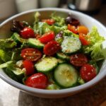Bowl of fresh salad with lettuce, cherry tomatoes, and cucumber slices for spring dinner recipes