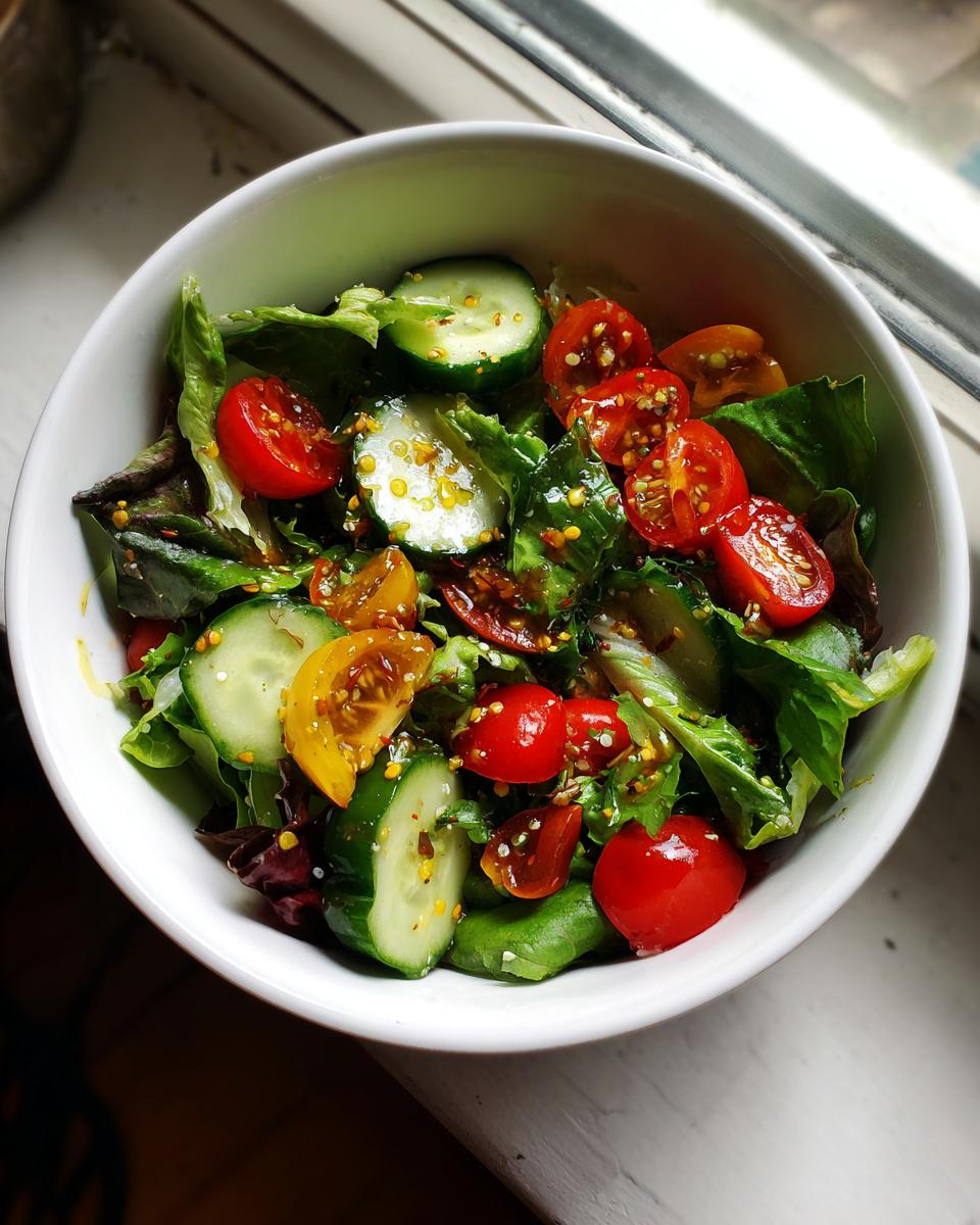 Bowl of fresh salad with cucumbers, cherry tomatoes, and leafy greens for spring potluck side dishes