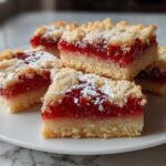 Close-up of jam bars with crumbly topping on a white plate for simple sweet recipes