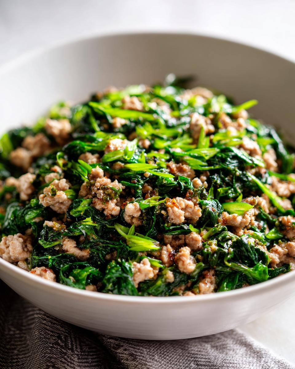 Bowl of cooked ground meat mixed with sautéed green leafy vegetables for low carb dinner recipes