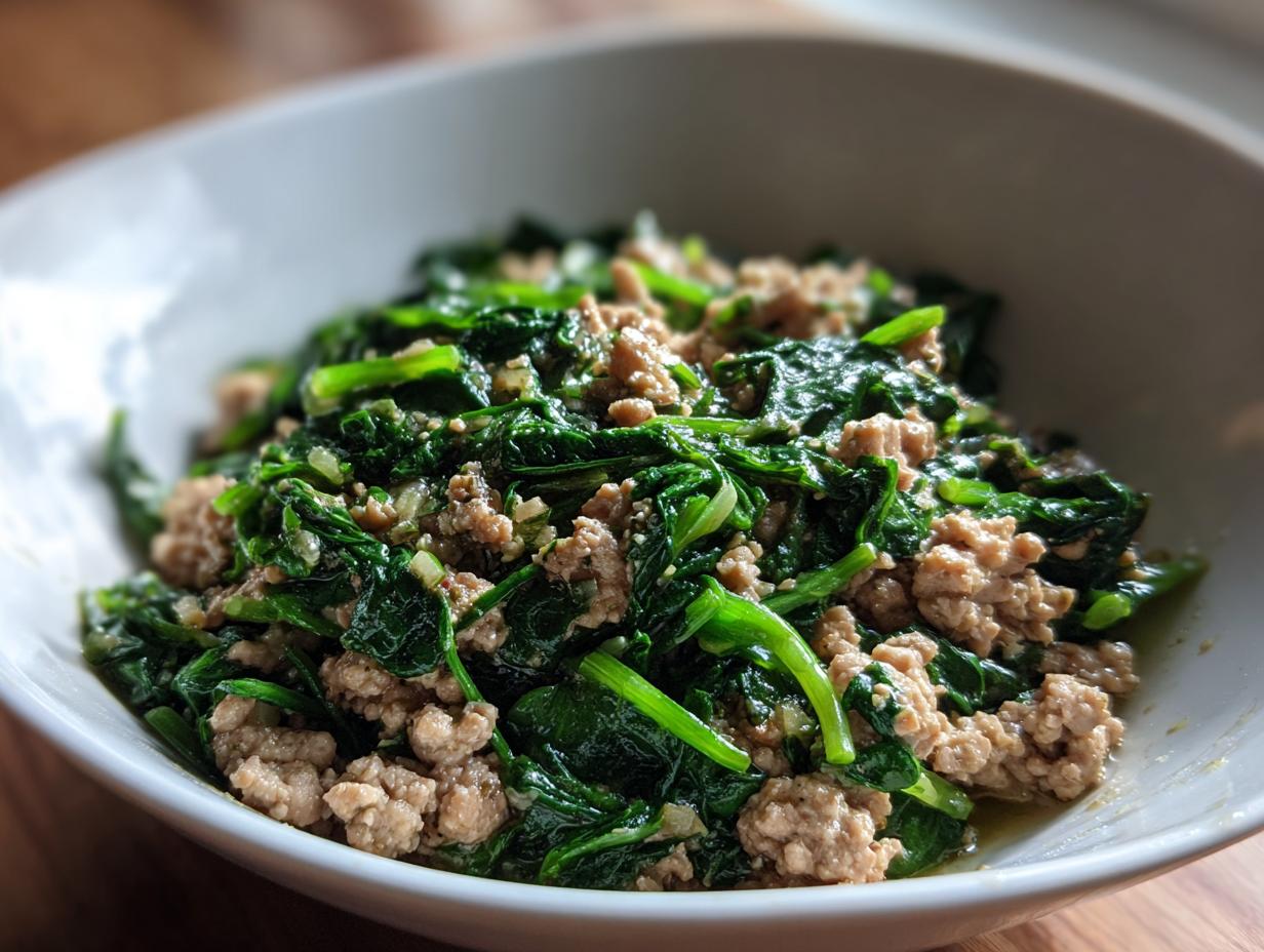 Bowl of cooked ground meat mixed with sautéed spinach for a low carb dinner recipe