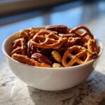 White bowl filled with mixed nuts and pretzels, a perfect easy snack recipes option.