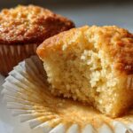 Two moist cupcakes with golden brown tops, one partially unwrapped showing soft crumb, easy cupcake ideas
