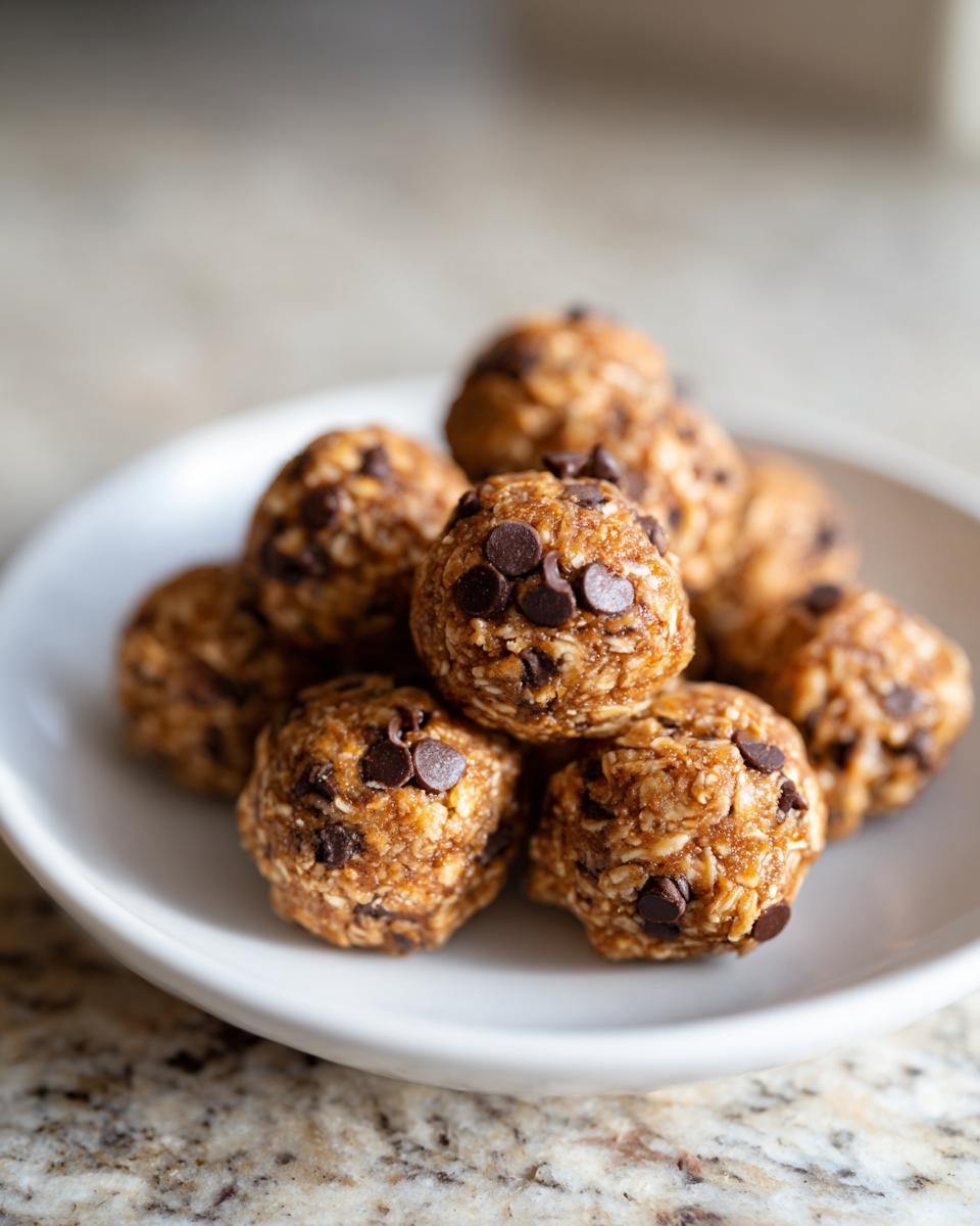 Close-up of no bake snack bites with oats and chocolate chips on a white plate.