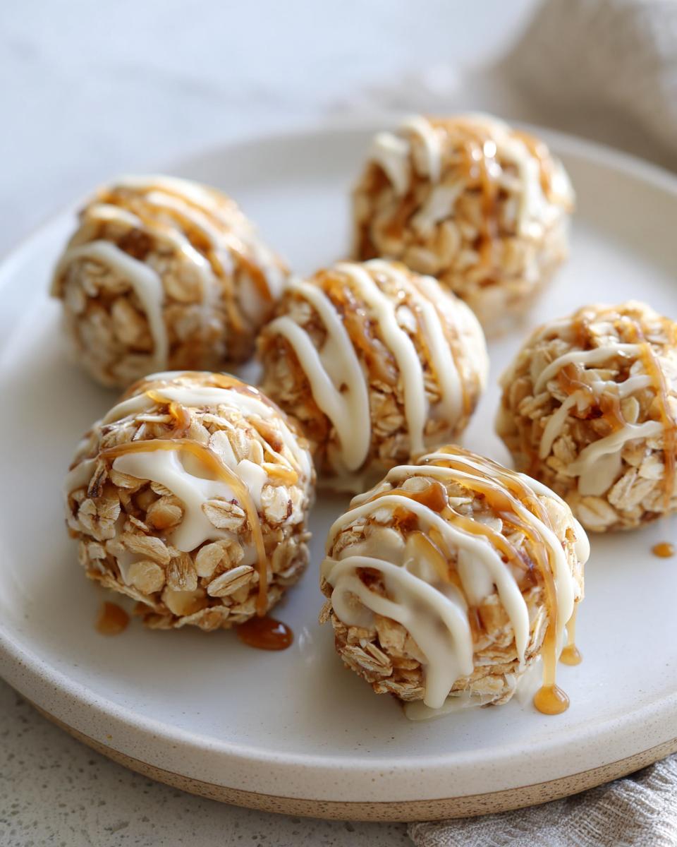 Close-up of peanut butter yogurt snack bites drizzled with white and caramel sauce on a white plate.
