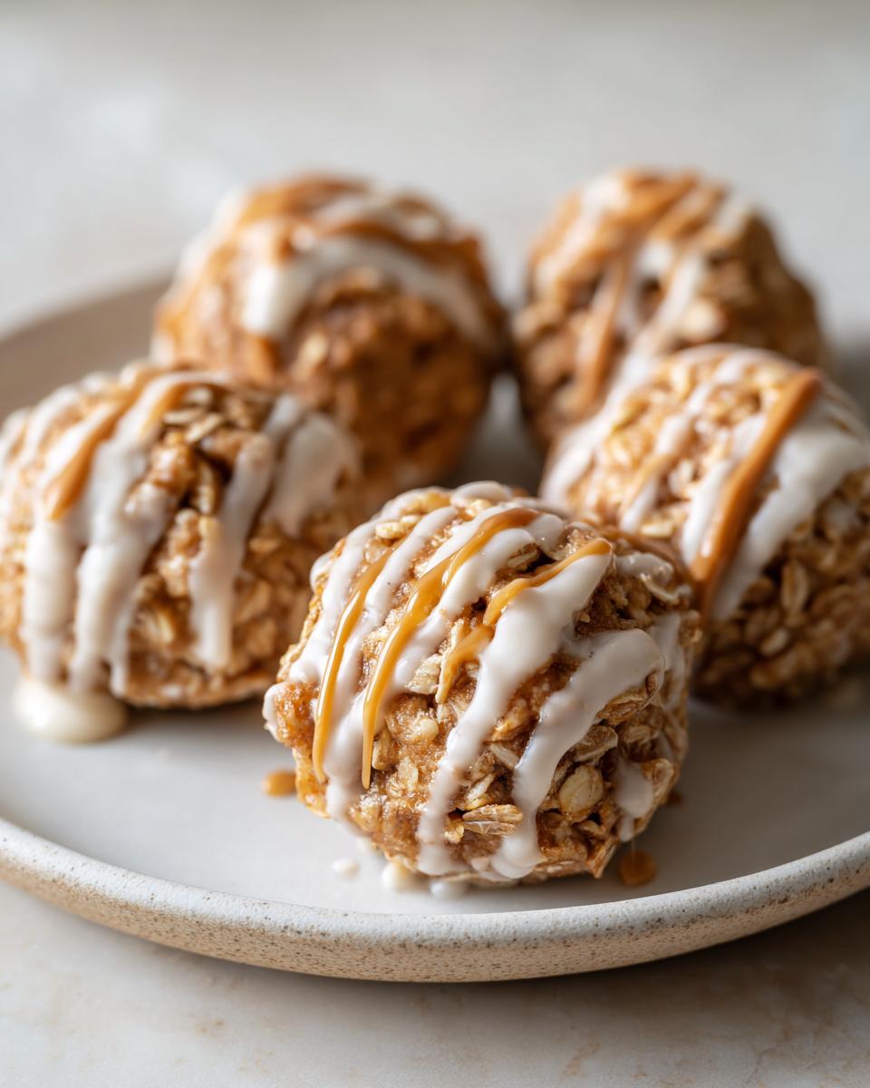 Close-up of peanut butter yogurt snack bites drizzled with white and peanut butter sauces on a beige plate.
