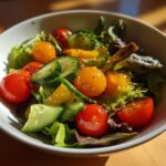 Bowl of fresh salad with cherry tomatoes, cucumber slices, and mixed greens for spring family meals