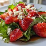 Close-up of fresh strawberry salad with greens and crumbled cheese, perfect spring holiday recipes dish.
