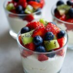 Glass cups filled with sweet cream cheese topped with strawberries, blueberries, and kiwi.