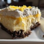 Close-up of a slice of Heavenly Lemon Oreo Dessert with creamy lemon filling and Oreo crust