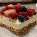 Slice of Very Berry Dessert Lasagna topped with strawberries, raspberries, and blueberries